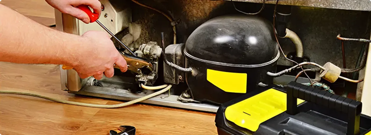 Refrigerator repair technician fixing the compressor and wiring in Gotha, FL