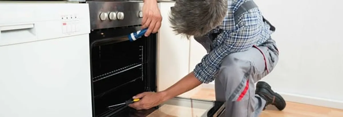 Oven repair technician inspecting and servicing an electric oven in Orlando, FL