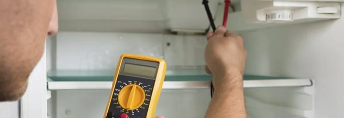 Refrigerator repair technician testing electrical components with a multimeter in Orlando, FL